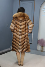 Load image into Gallery viewer, Full length muskrat fur hooded coat with racoon trim
